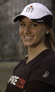 A woman wearing a hat and smiling for the camera.