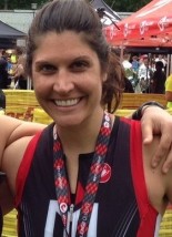 A woman smiling with her arms around her neck.