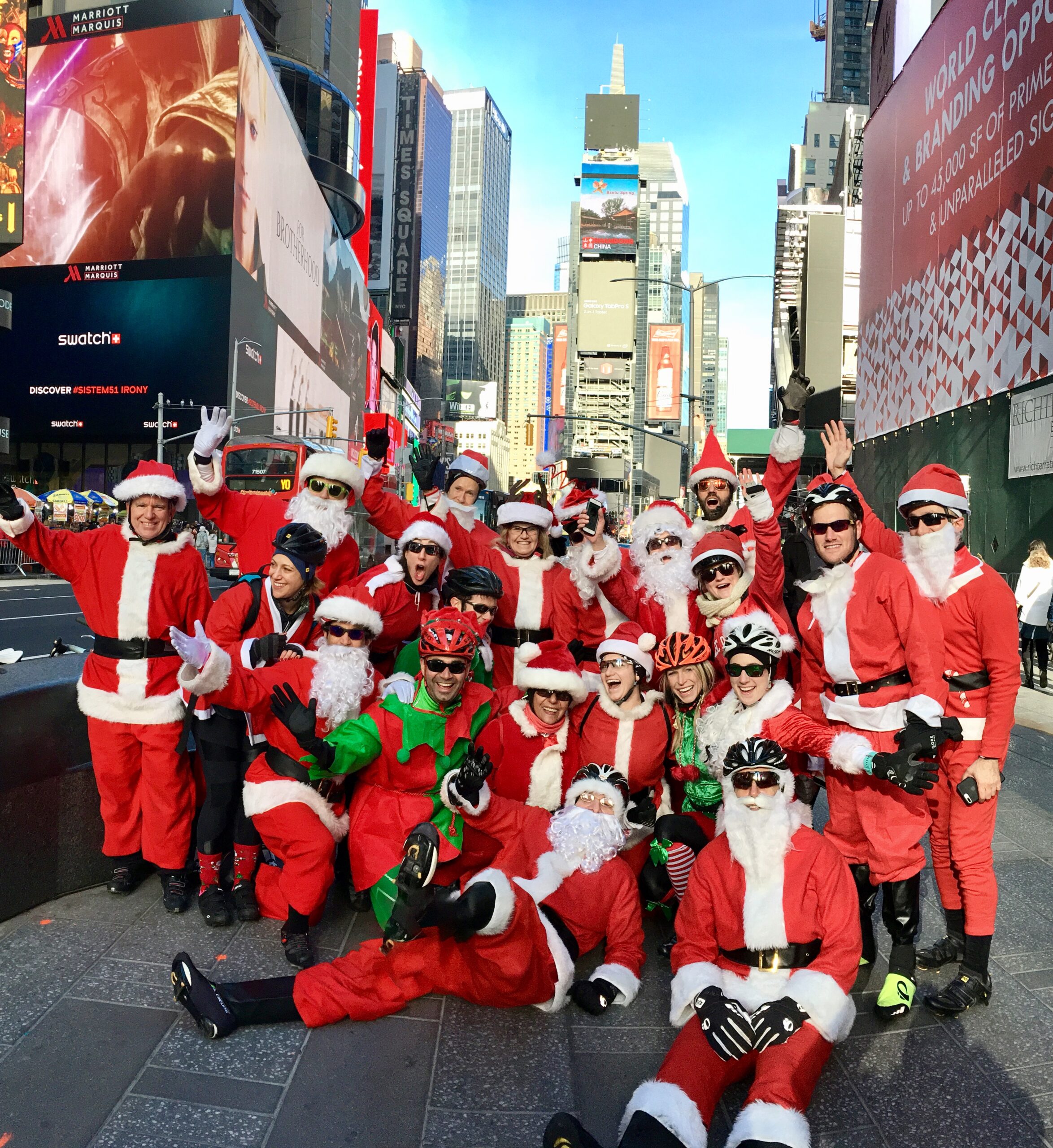 A group of people dressed as santa claus in the street.
