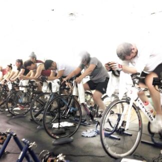 A group of people riding bikes in a room.