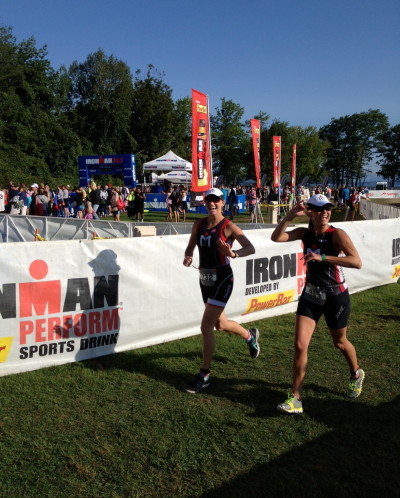 Two women running in a race on grass.