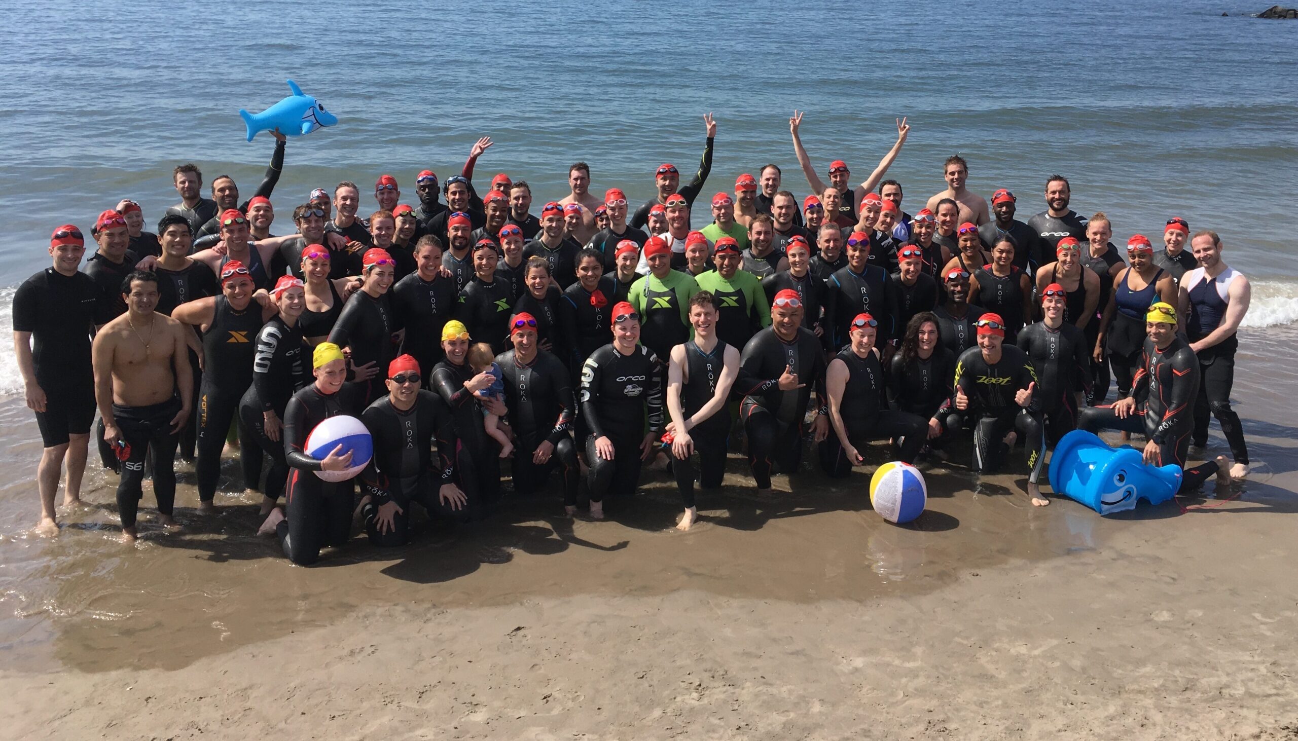 A group of people standing on top of a beach.