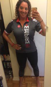 Woman taking mirror selfie in cycling outfit.