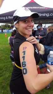 Smiling athlete with race number on arm.