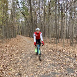 A person riding a bike on a trail in the woods.