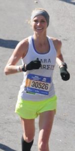 Smiling runner in race with bright shorts.