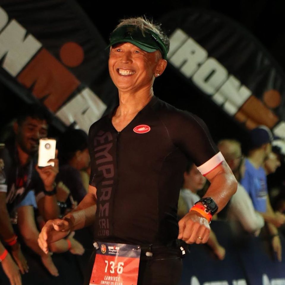 A man in black shirt standing next to crowd.