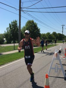 Man running in a triathlon, high-fiving.