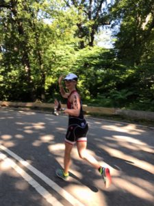 Runner in athletic gear on sunny road.