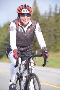 Cyclist smiling while riding a bicycle.