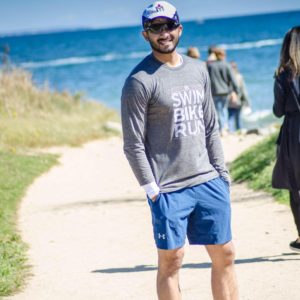 Man smiling on a beachside path.