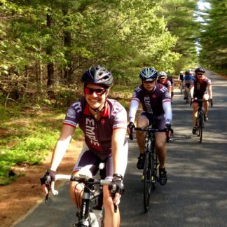 A group of people riding bikes down the road.