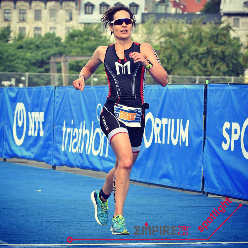 A woman running on the side of a blue track.
