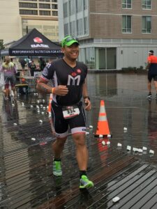 Runner smiling during a rainy outdoor race.