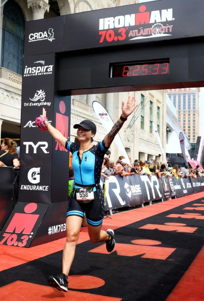 Triathlete celebrating at Ironman finish line.