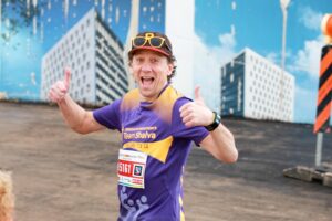 Runner smiling and giving thumbs up.