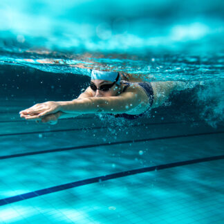 A woman swimming in the pool under water.