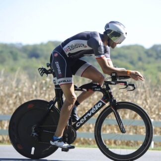 A man riding a bike on the road near trees.