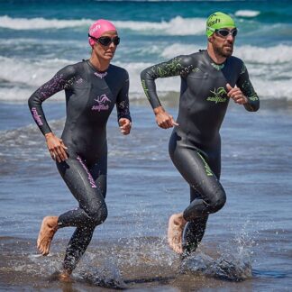 Two men in wetsuits running through water.