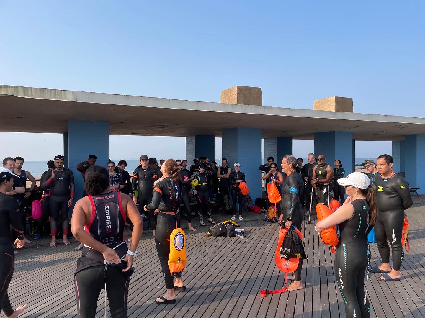 A group of people standing on top of a wooden deck.