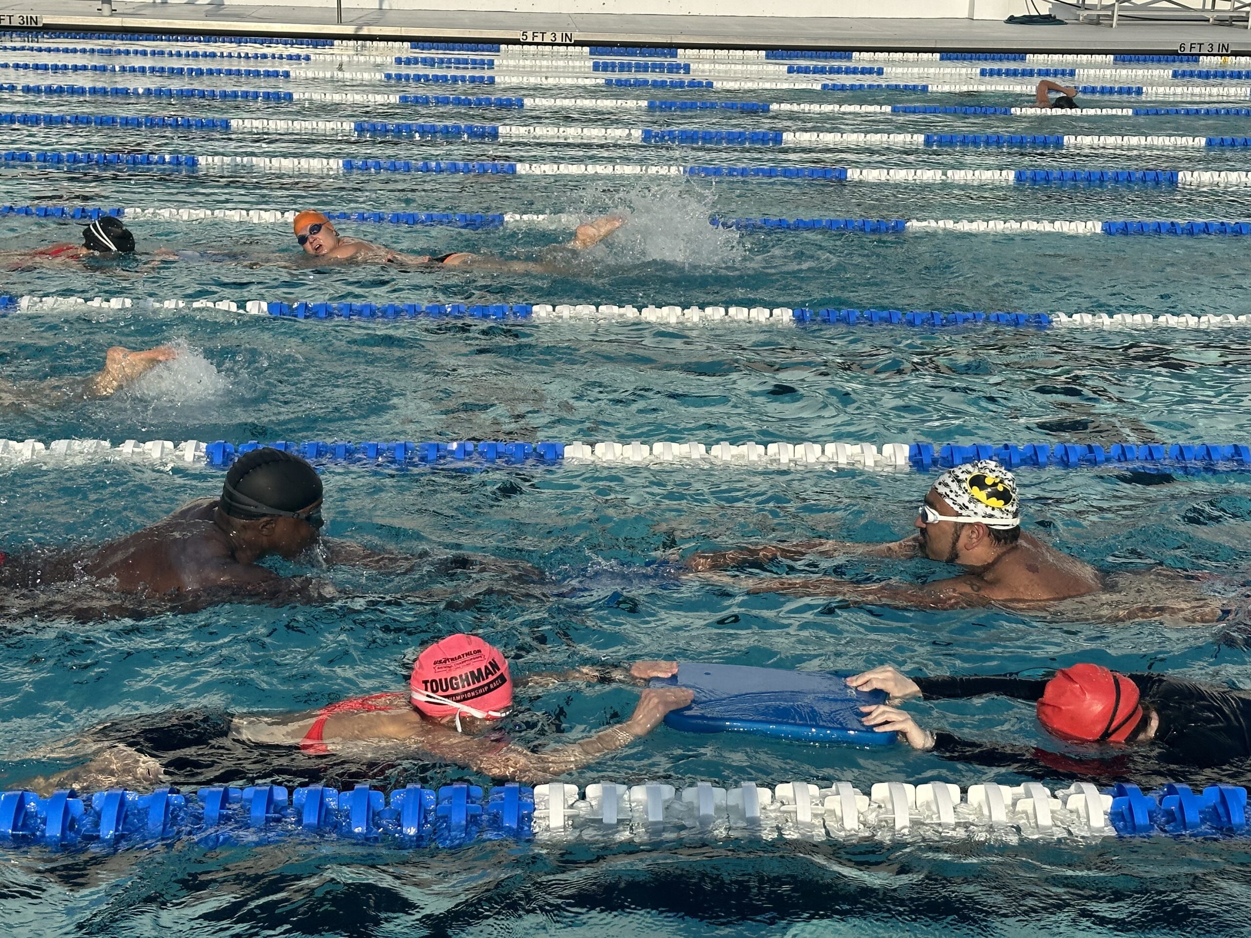 A group of people swimming in the pool.