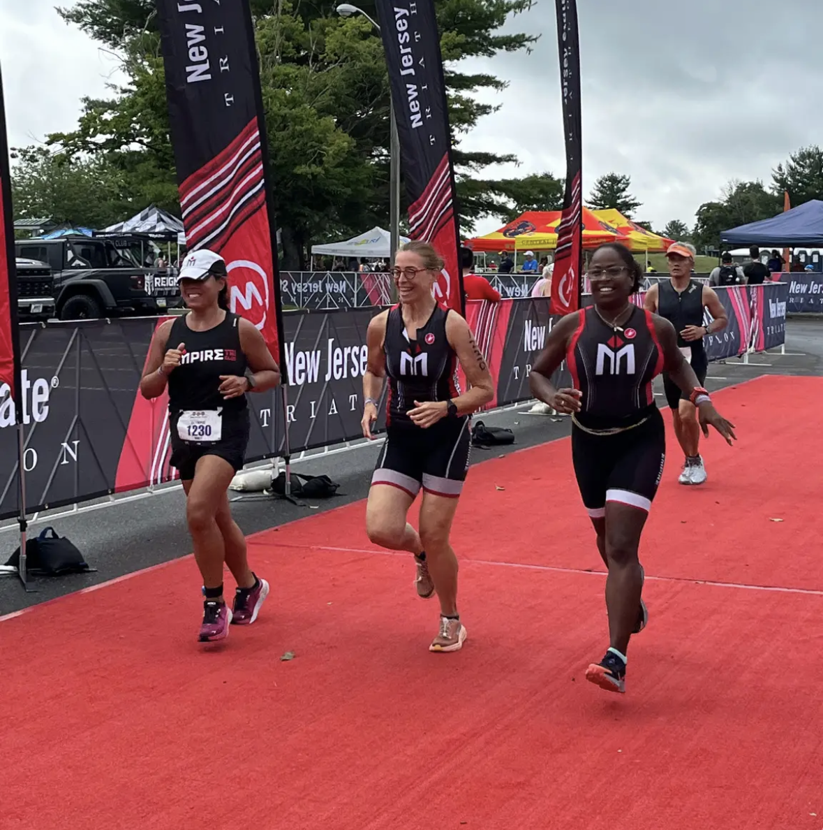 Three women running in a race on the side of a road.