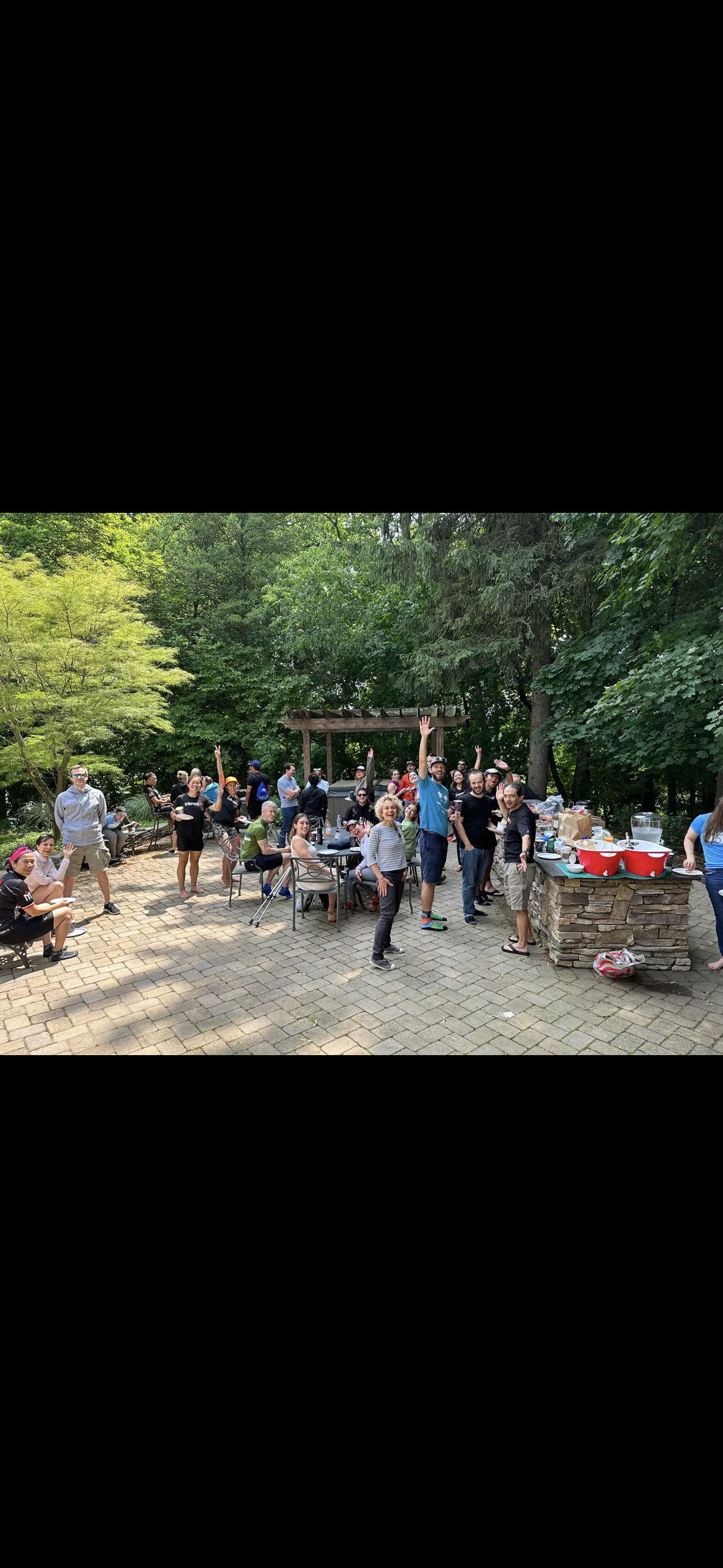 A group of people standing around an outdoor table.